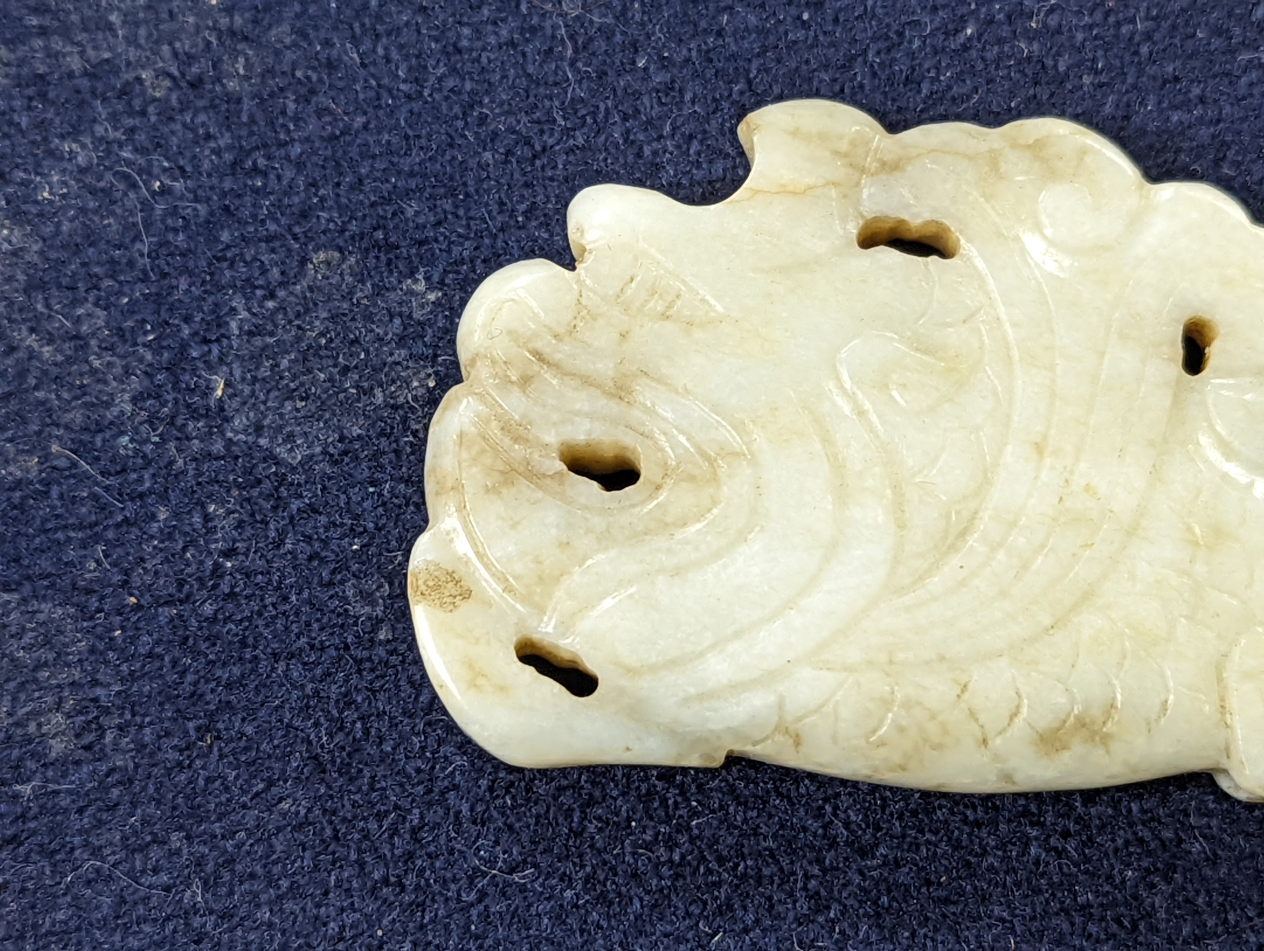 A Chinese white and black jade ‘dragon-fish’ plaque, 19th/20th century, 6cm
